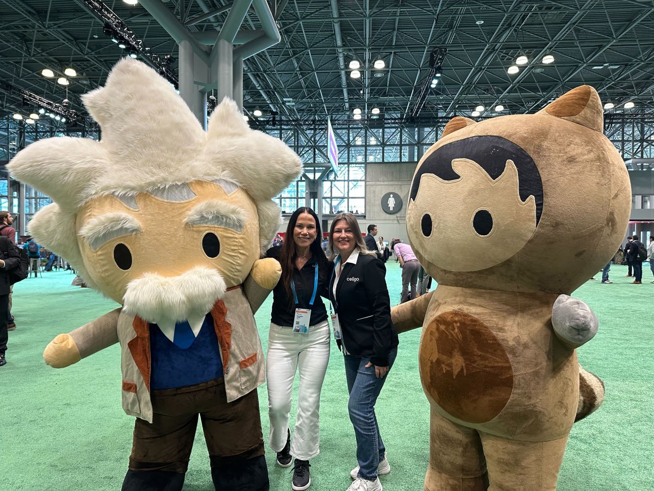 Celigo team members pose with Salesforce mascots at Salesforce World Tour.
