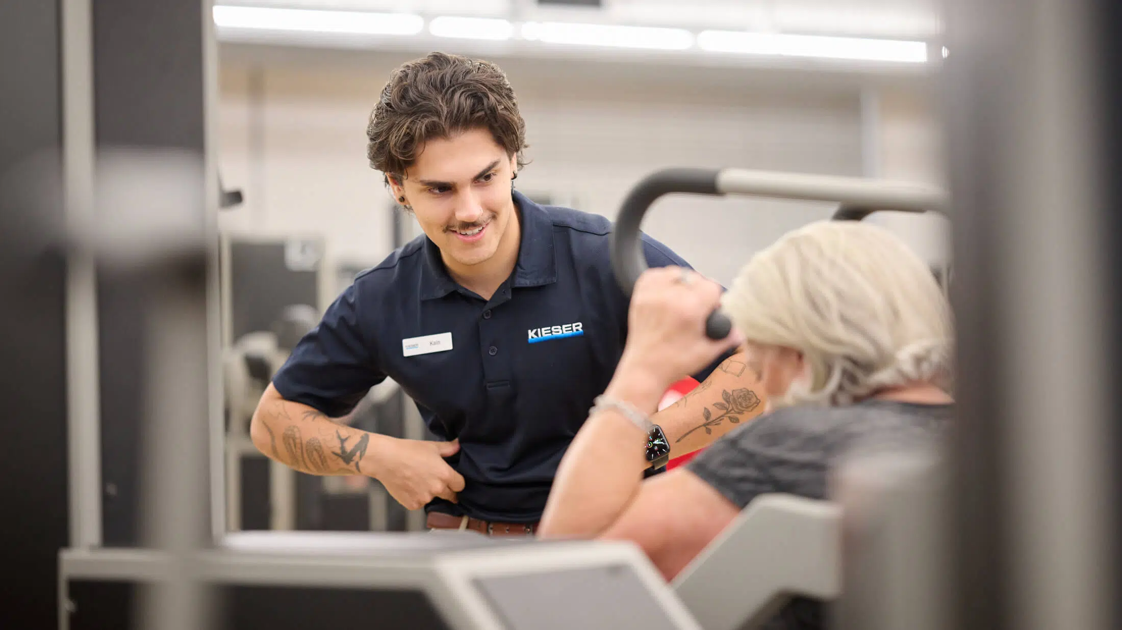 A Kieser Australia physiotherapist assisting a client with strength training
